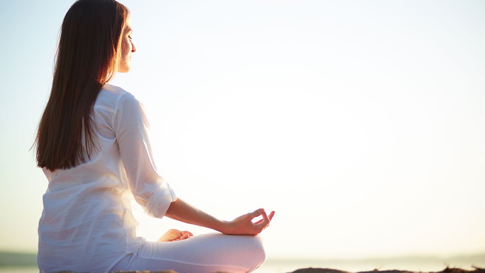 Person meditating in a serene environment to block out mental noise and achieve clarity.